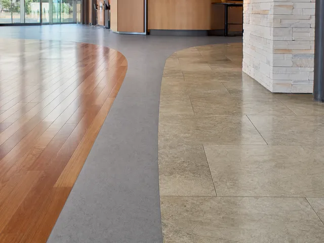 Unterschiedliche Bodenbeläge als Symbol für materialgerechte Pflege bei der Grundreinigung